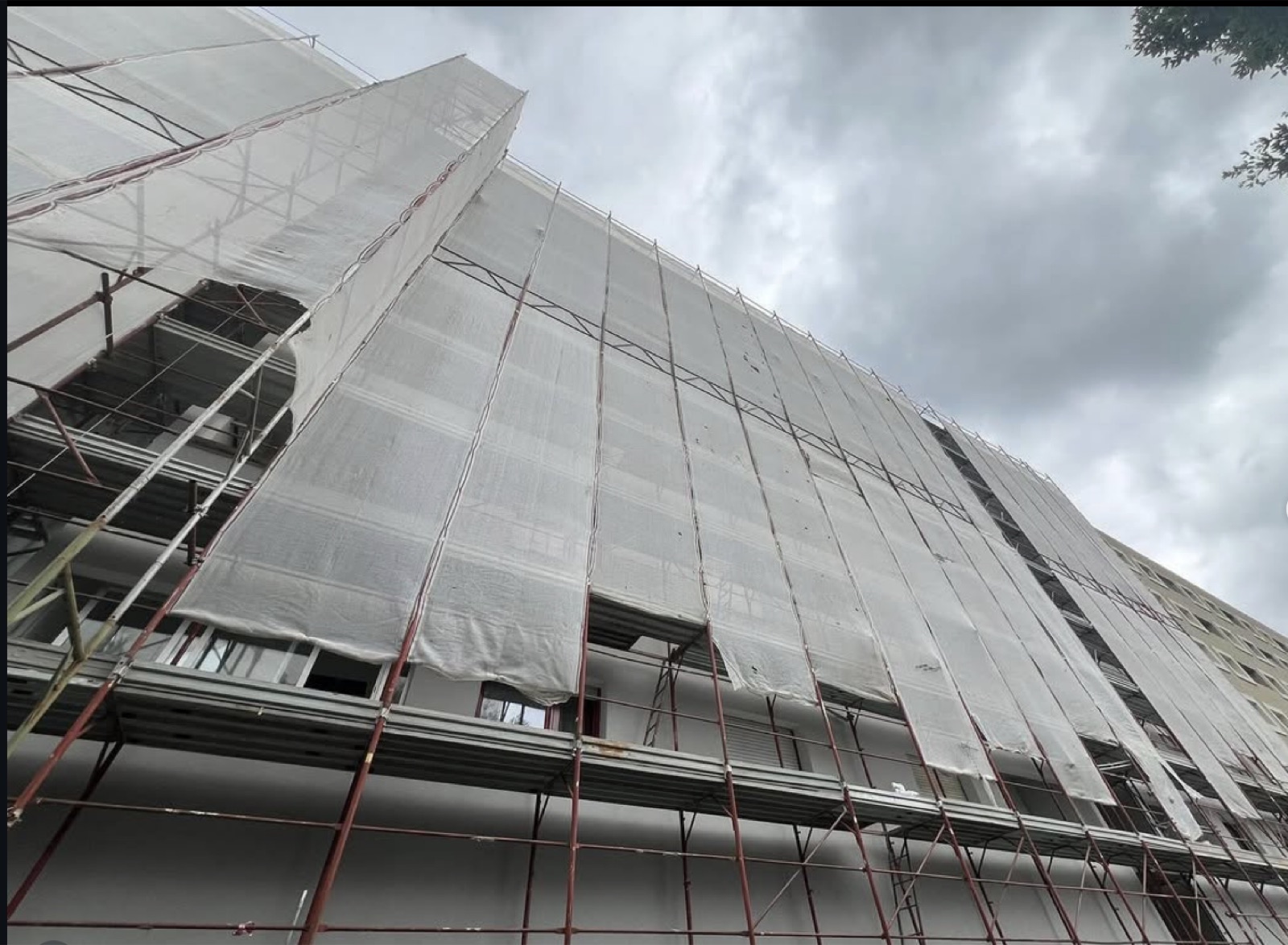 Riqualificazione energetica di un condominio, Il ponteggio coperto dai teli durante la posa del cappotto.