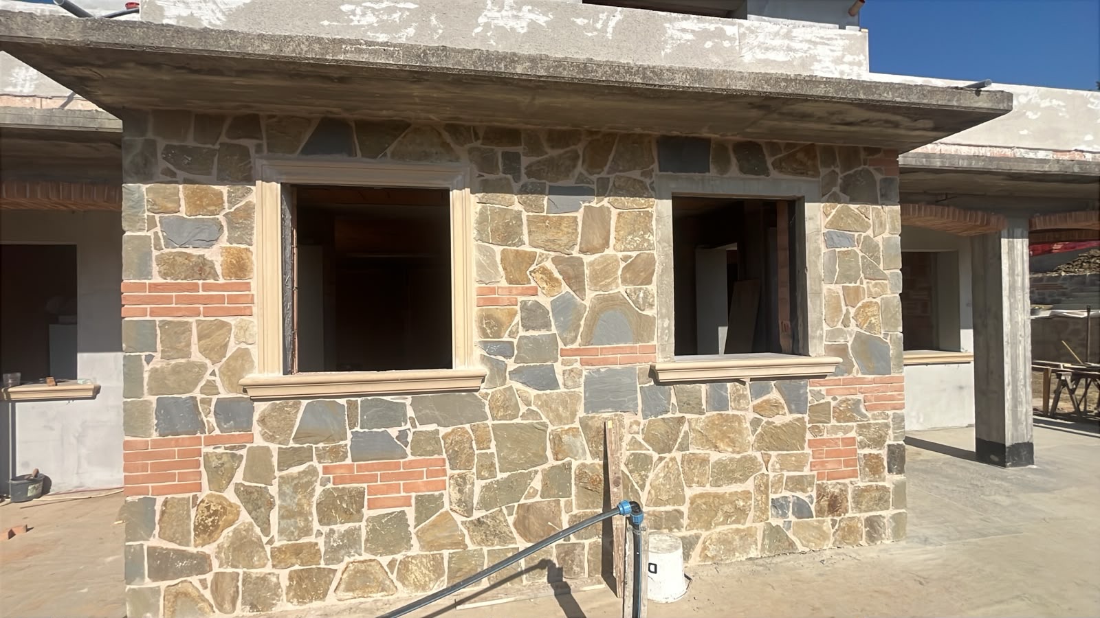 Villa trifamiliare di nuova costruzione, Il rivestimento in pietra in corso di posa.