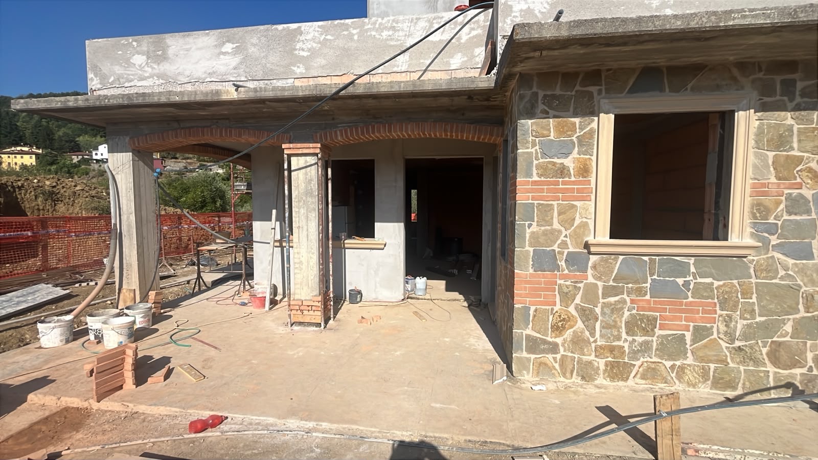 Villa trifamiliare di nuova costruzione, Le murature rivestite e gli stipiti in pietra.