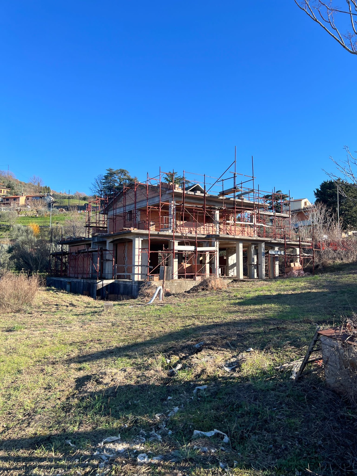 Villa trifamiliare di nuova costruzione, La struttura in elevazione sul terreno in pendio.