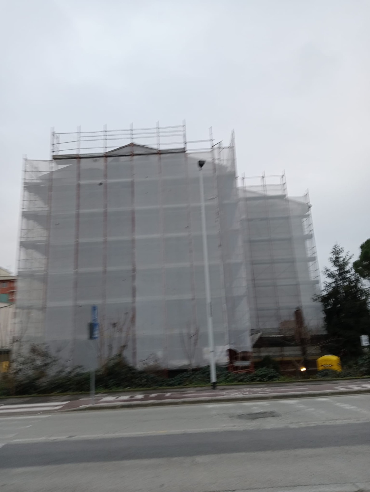 Efficientamento energetico di uno stabile condominiale, L’edificio fasciato dai teli durante i lavori.